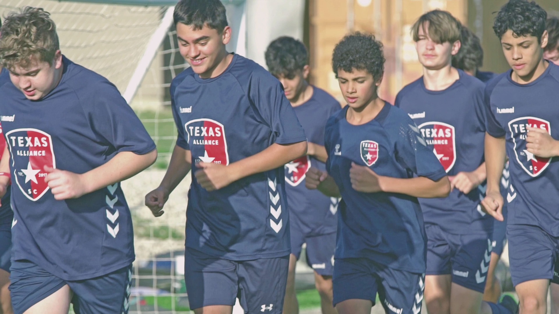 Jugadores de futbol trotando alrededor de la cancha